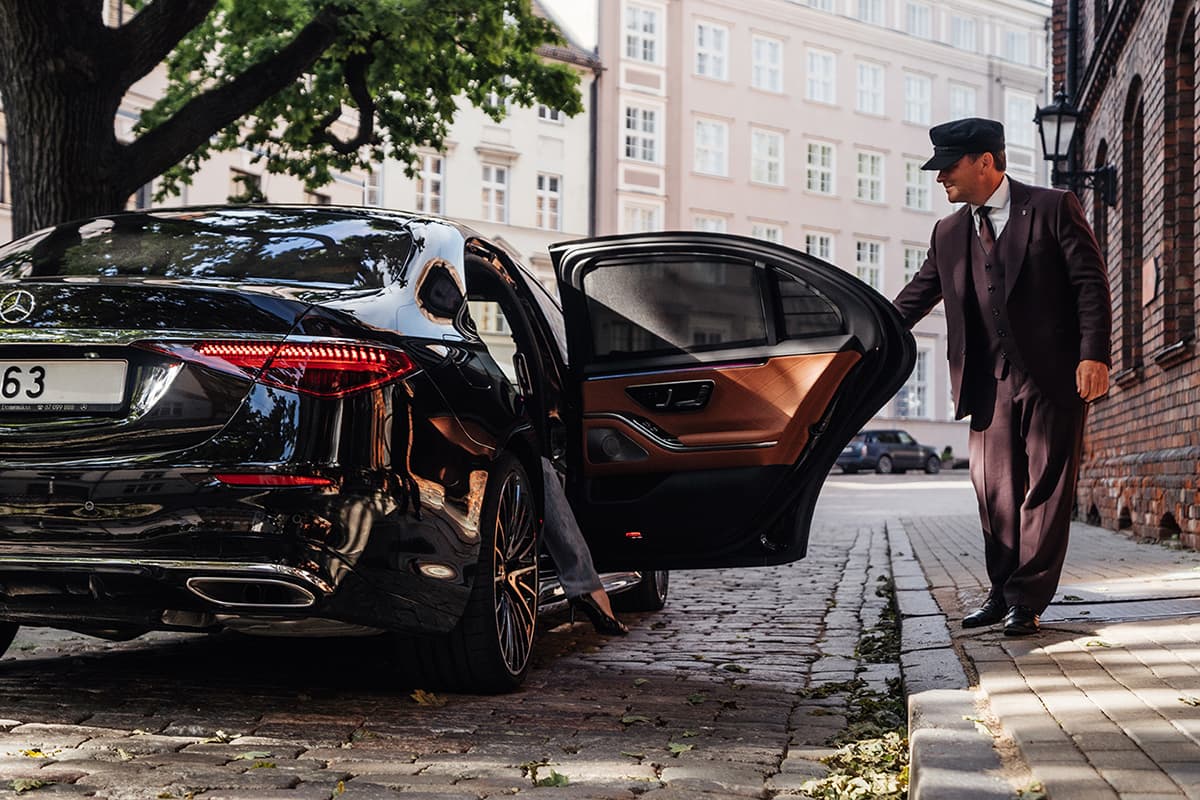 Corporate Chauffeur is opening a door for a business person in Los Angeles