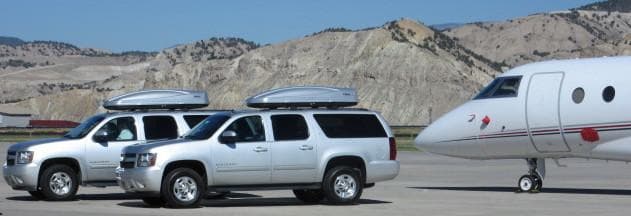 2 Silver Suvs In Front Of Private Plane