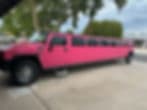 Pink Hummer limousine parked in a driveway