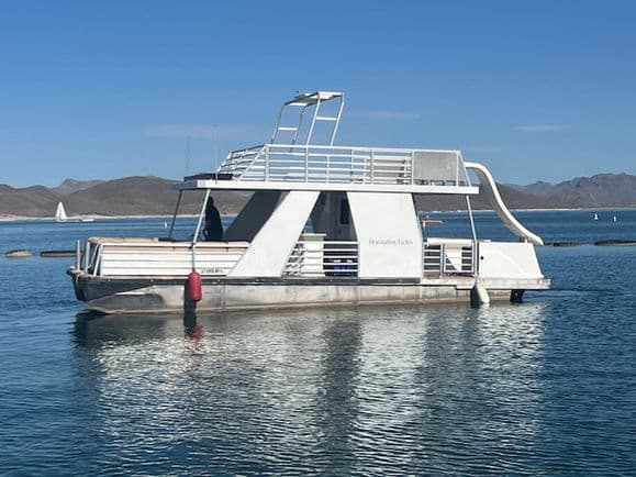 Large white party boat with a slide on the water