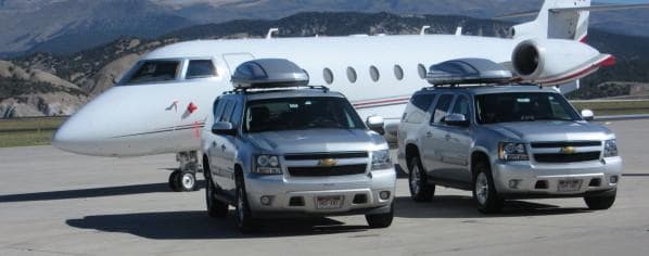 2 Silver Suvs In Front Of Whole Private Plane